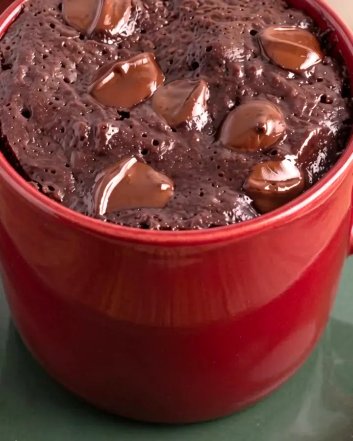Brownie au chocolat fondant servi encore tiède dans un mug en céramique posé sur une soucoupe