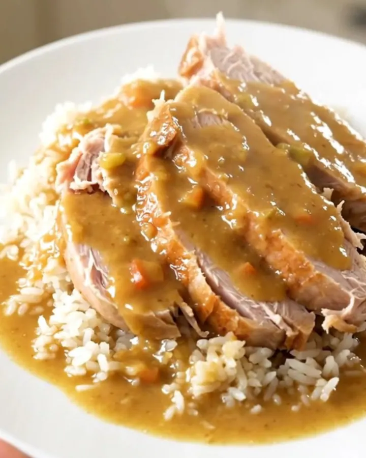 A close-up shot of creamy ranch turkey tenderloin served over white rice with tender carrots.