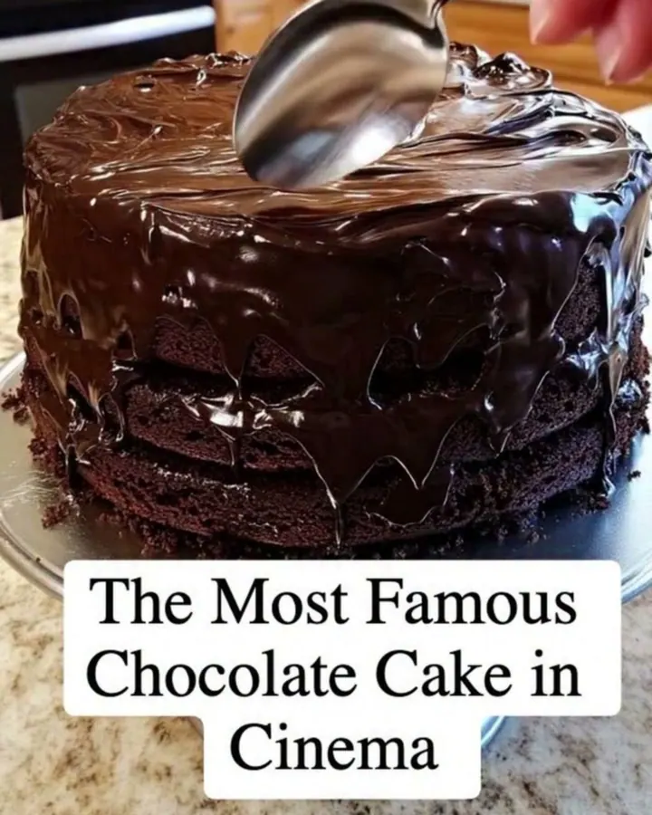 Gâteau au chocolat fudge à trois étages, glaçage brillant lissé sur un plat argenté