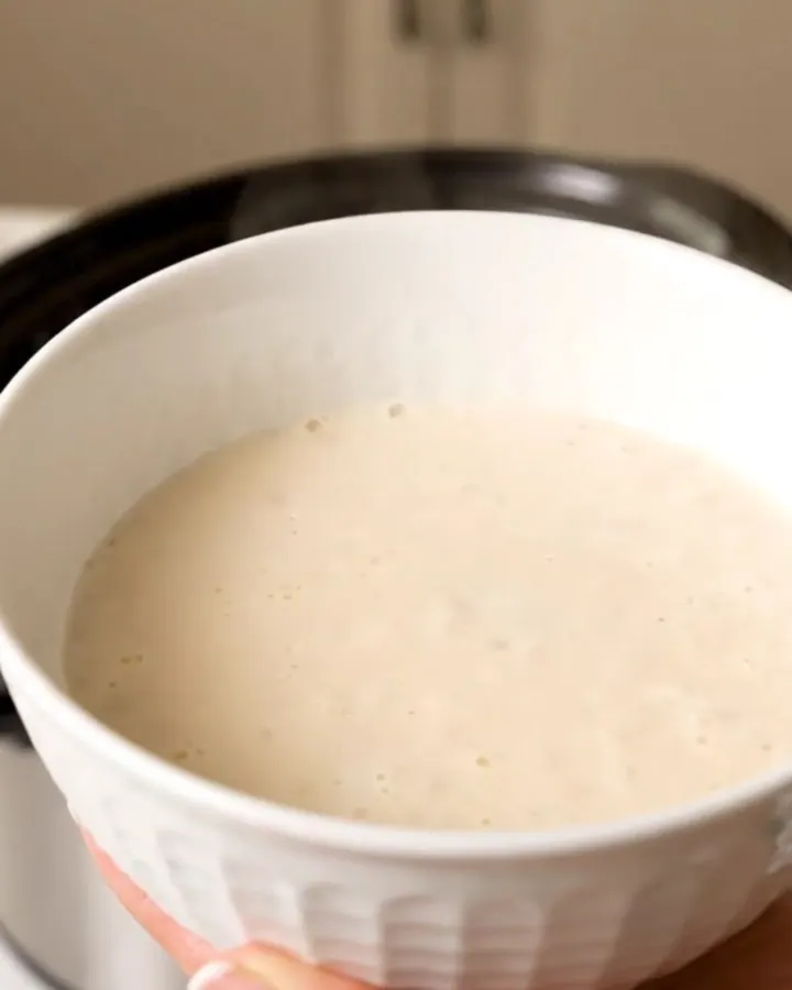 A warm bowl of creamy homemade eggnog garnished with a light dusting of freshly grated nutmeg.