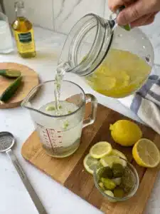 This pickle lemonade drink blends dill pickle brine and lemon juice, served ice-cold for a bold, tangy refreshment with a hint of sweetness.