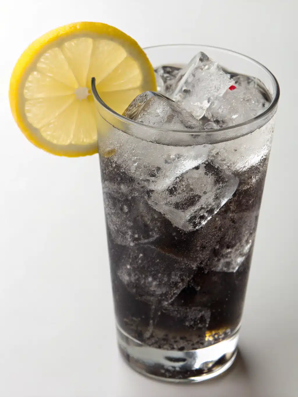 Serving ideas for charcoal lemonade recipe Elegant glass of charcoal lemonade with lemon slice and mint garnish