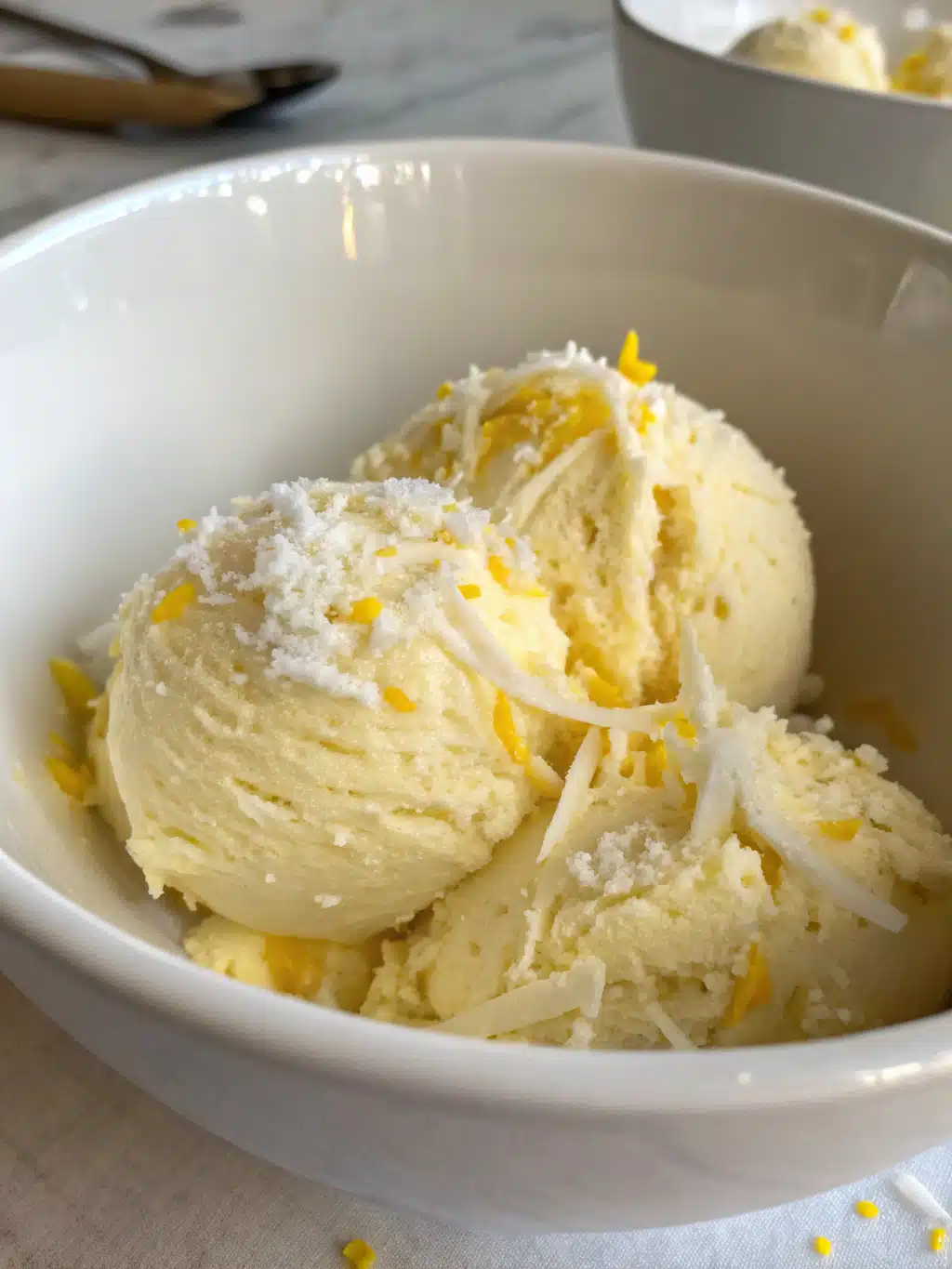 Lemon coconut gelato served in a coconut shell with fresh berries