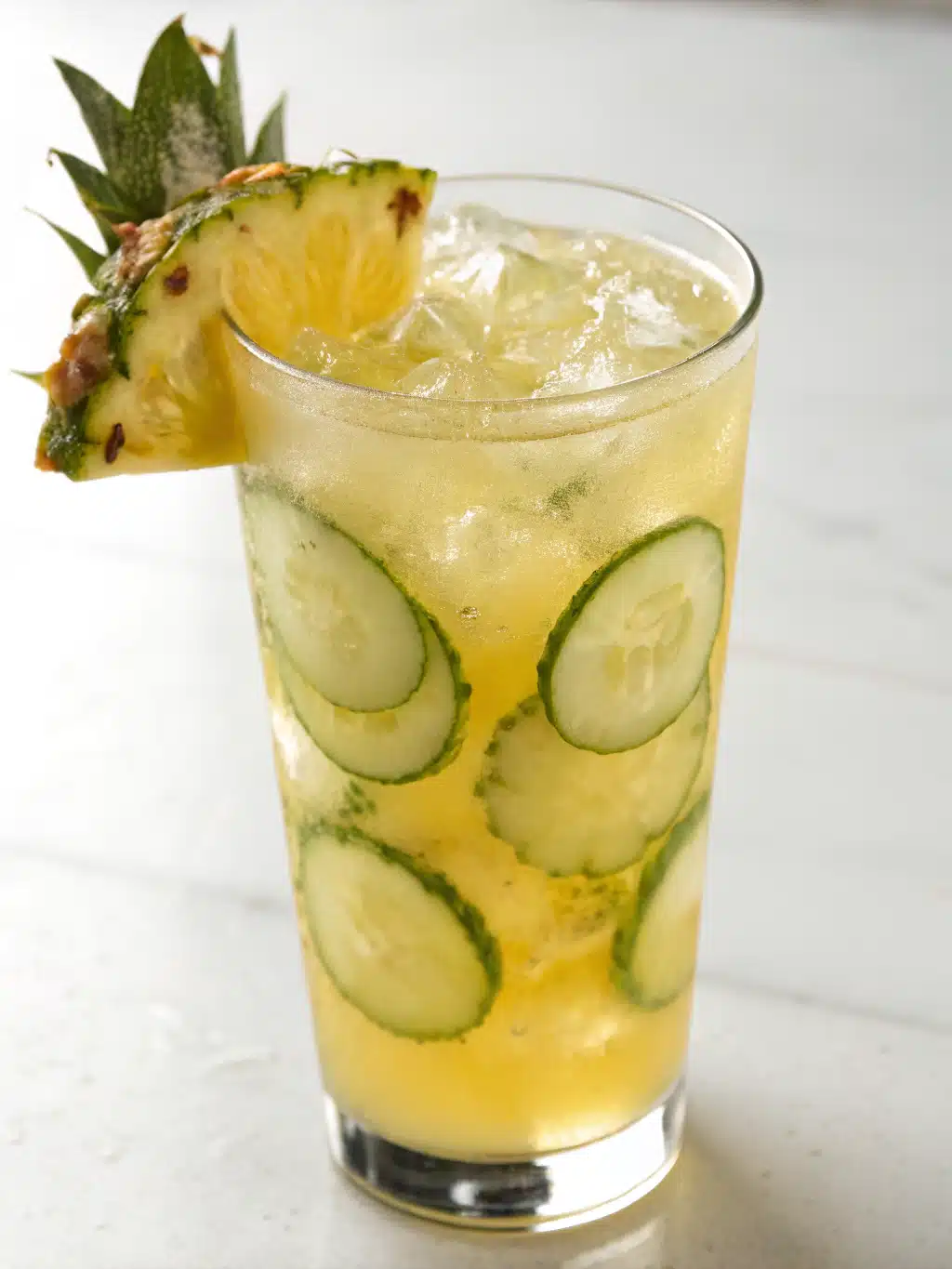 Serving pineapple cucumber juice with style Elegant glass of pineapple cucumber juice with mint garnish
