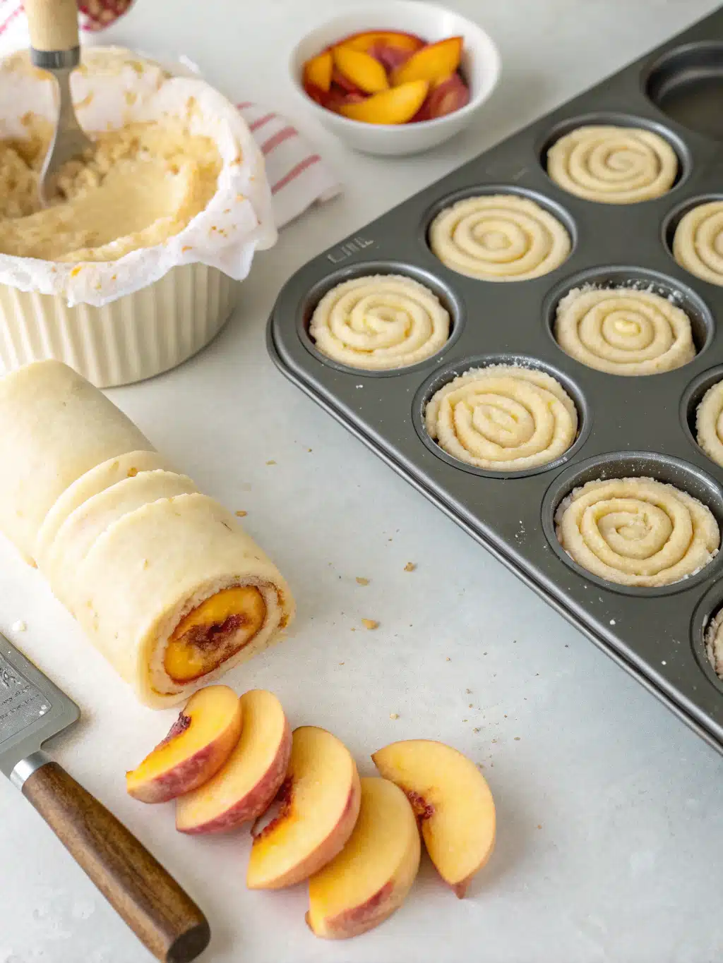 Rolling peach-filled dough into a log for cruffins