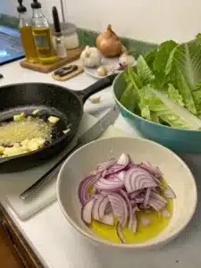 Wilted lettuce salad with romaine, dressed in warm garlic butter and topped with hard-boiled eggs. Serve immediately for perfect texture.