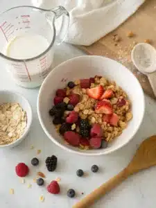 Indulge in a creamy fruity pebbles cheesecake with a graham cracker crust, topped with whipped cream and colorful cereal for a fun dessert.