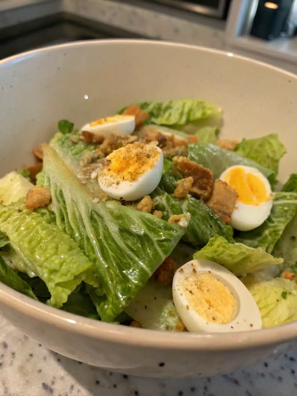 Wilted lettuce salad with romaine, dressed in warm garlic butter and topped with hard-boiled eggs. Serve immediately for perfect texture.