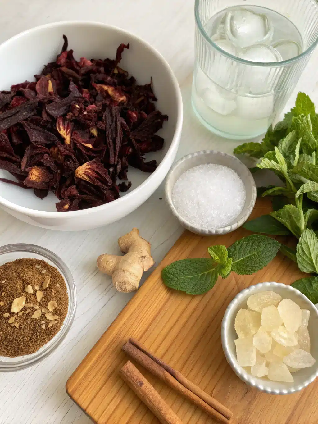 Colorful ingredients for homemade hibiscus tea recipe laid on a rustic table