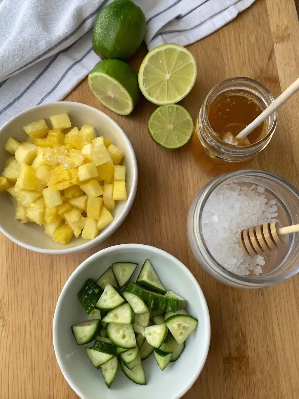 Vibrant ingredients for homemade juice Fresh pineapple, cucumber, lime, and honey arranged for pineapple cucumber juice