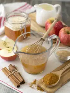 Refreshing apple cider vinegar drink with honey and cinnamon, served over ice with lemon slices for a tangy, revitalizing beverage.