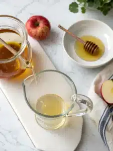 Refreshing apple cider vinegar drink with honey and cinnamon, served over ice with lemon slices for a tangy, revitalizing beverage.