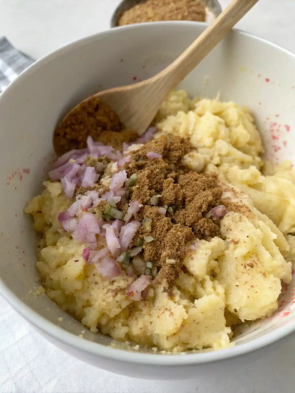 Rolling out stuffed Aloo Paratha dough on a wooden board