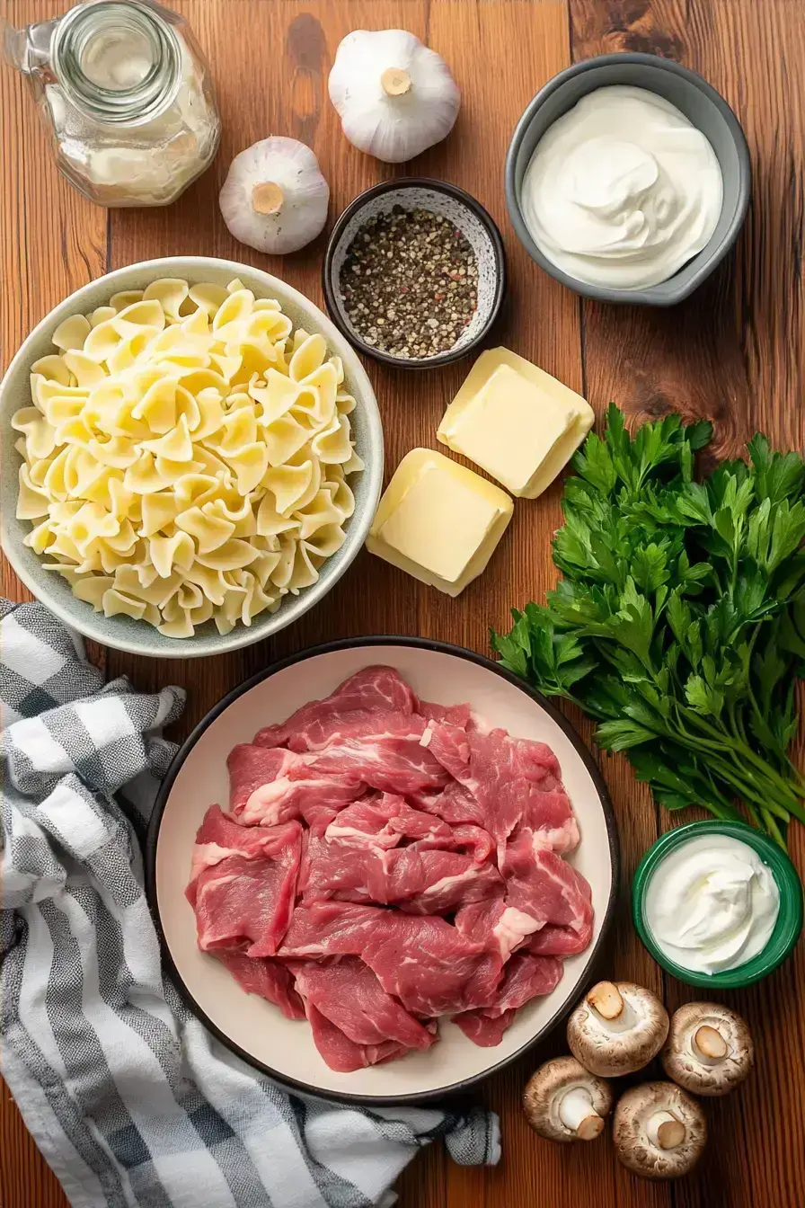 Ingredients for making Beef Stroganoff including steak, mushrooms, and seasonings