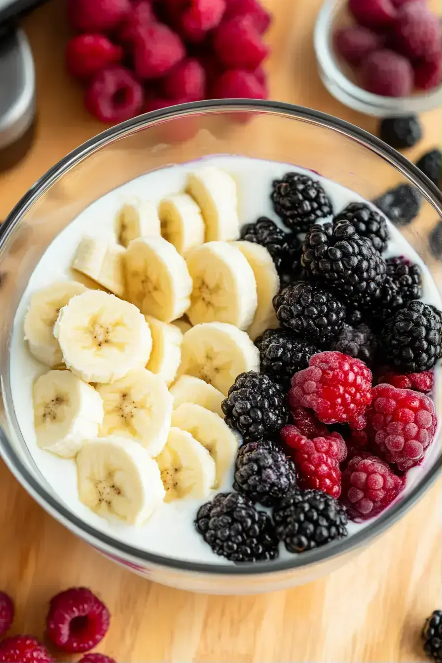 Blending blackberry smoothie ingredients into a smooth purple mixture