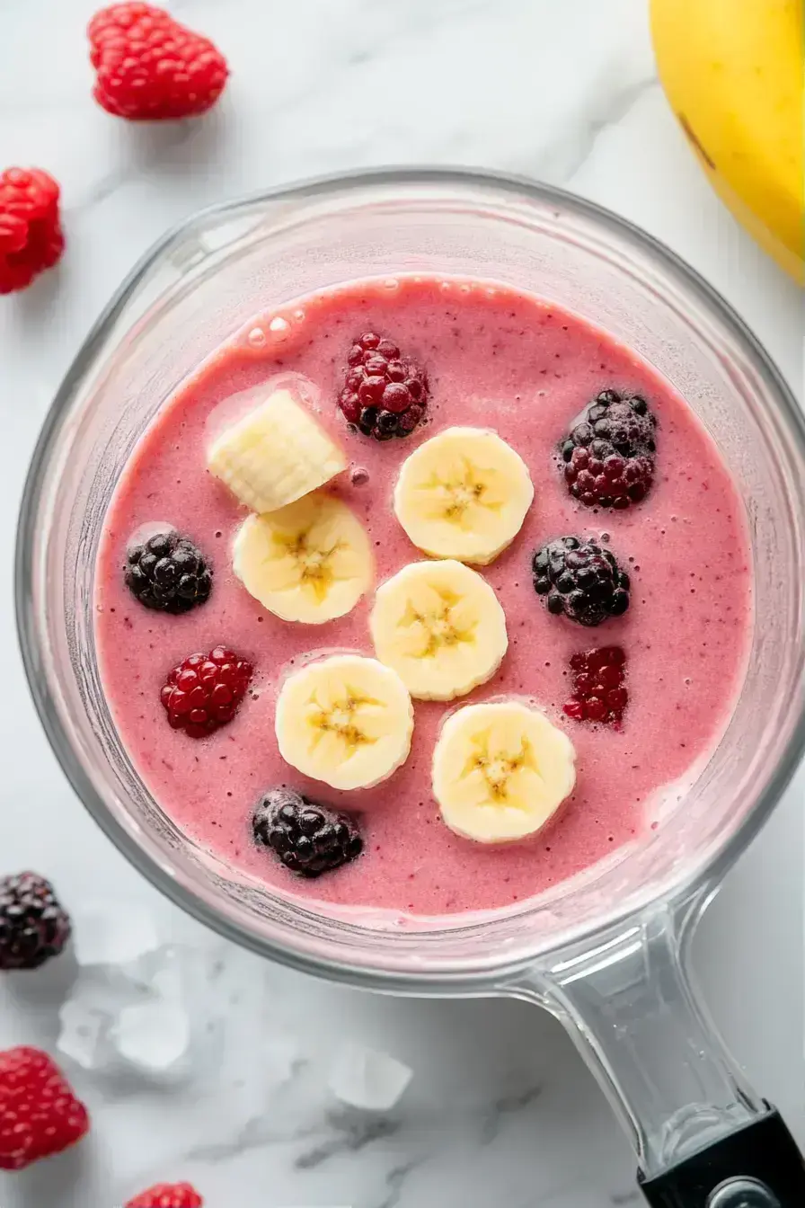 Scraping down the sides of the blender for a perfectly smooth blackberry smoothie