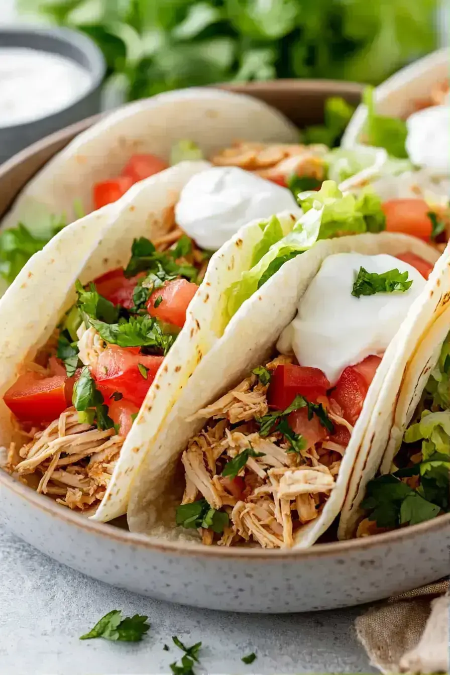 Beautiful serving platter of chicken tacos with various toppings and side dishes arranged family-style