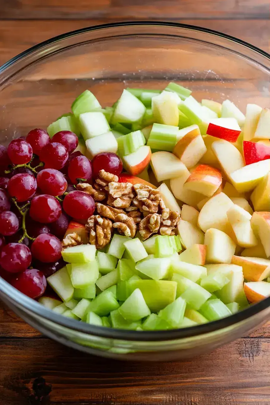 Whisking the tangy yogurt dressing for Waldorf Salad in a small bowl