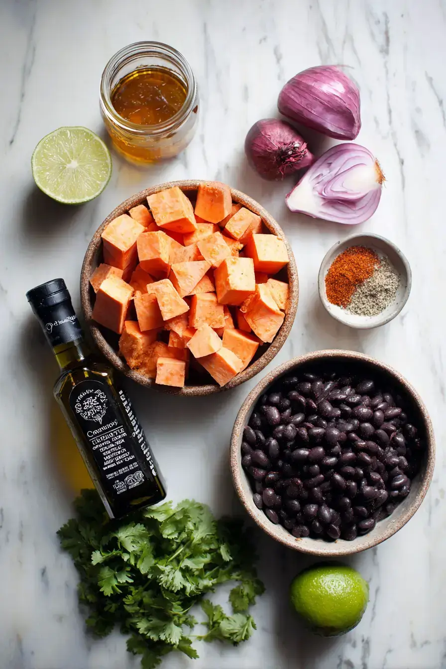 Assembled ingredients for making a sweet potato black bean salad on a wooden table